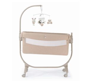 culla beige su struttura con ruote e giostrina con peluche appesi vista laterale