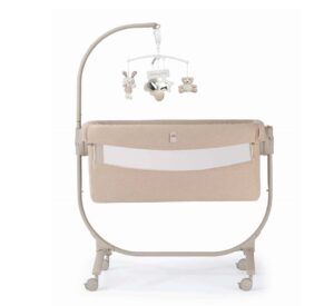 culla beige con struttura su ruote e giostrina con peluche vista laterale