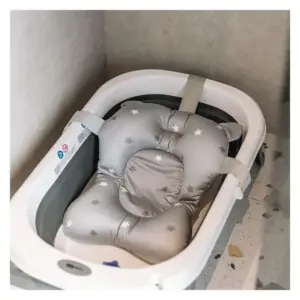 Cuscino morbido grigio con stelle per il bagnetto posizionato all'interno di una vaschetta bianca