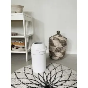Contenitore Magic Mangiapannolini bianco posizionato su tappeto decorato con mobiletto e cesta intrecciata sullo sfondo