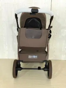 Vista posteriore del passeggino con maniglione imbottito e borsa coordinata in tessuto marrone