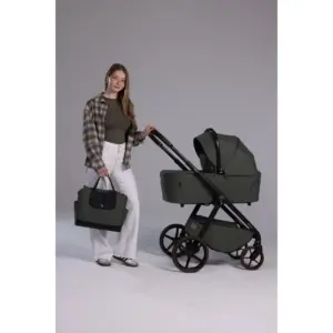 Donna in piedi accanto a passeggino trio con navicella e borsa coordinata verde scuro
